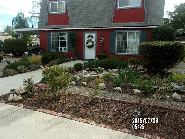 view of front of home featuring a shingled roof and a balcony