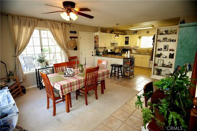 dining room featuring light tile patterned floors, a textured ceiling, and a ceiling fan