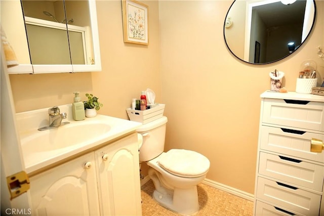 bathroom featuring toilet, baseboards, and vanity