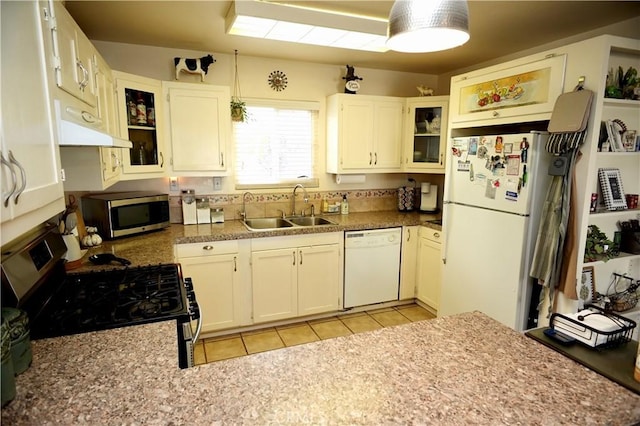 kitchen with glass insert cabinets, appliances with stainless steel finishes, white cabinets, and a sink