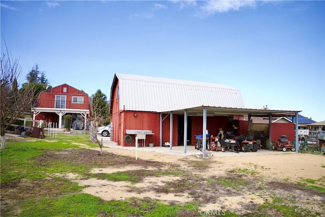 view of outdoor structure with driveway, a carport, and an outdoor structure