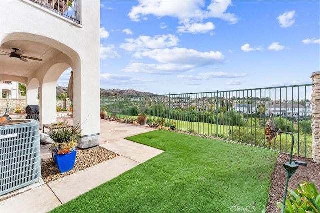 view of yard featuring ceiling fan, a patio area, a balcony, and central air condition unit