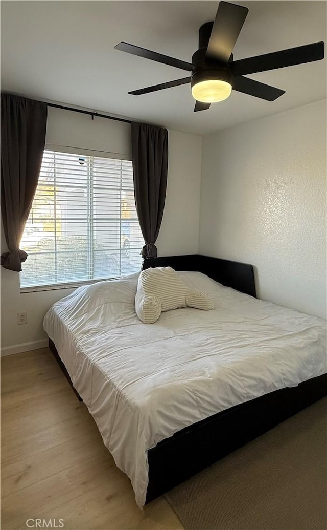 bedroom with ceiling fan and light hardwood / wood-style flooring