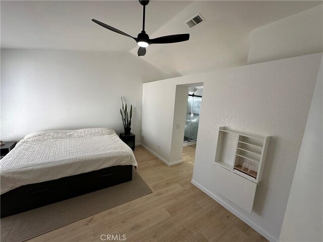 bedroom with ceiling fan, light wood-type flooring, and lofted ceiling