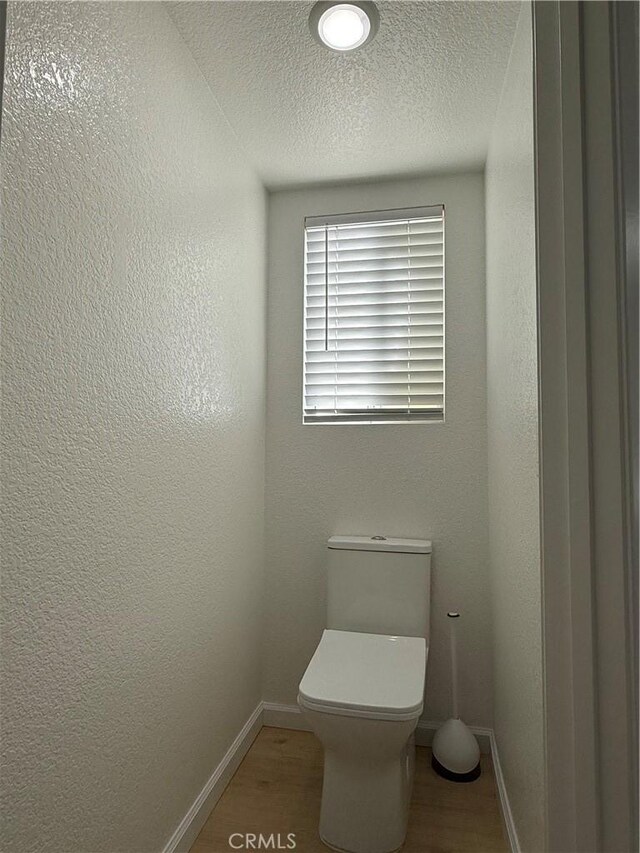 bathroom with hardwood / wood-style floors and toilet