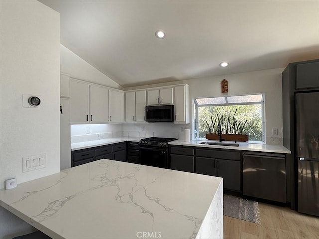 kitchen with kitchen peninsula, gray cabinetry, vaulted ceiling, white cabinets, and black appliances