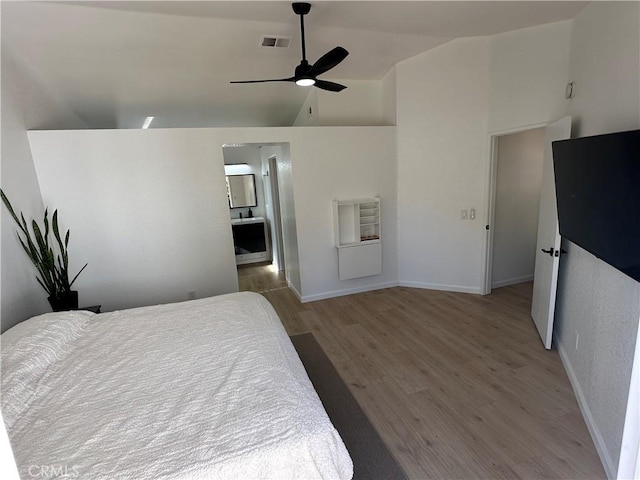 bedroom with ceiling fan, ensuite bath, hardwood / wood-style floors, and lofted ceiling