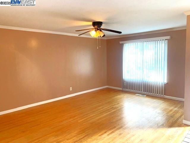 spare room with ceiling fan, wood-type flooring, and crown molding