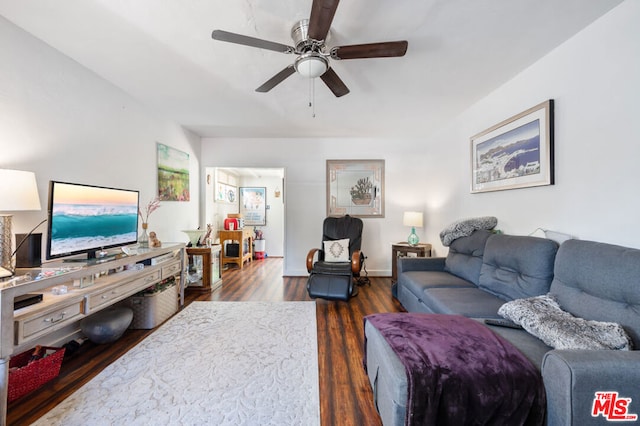 living room featuring ceiling fan and dark wood-type flooring