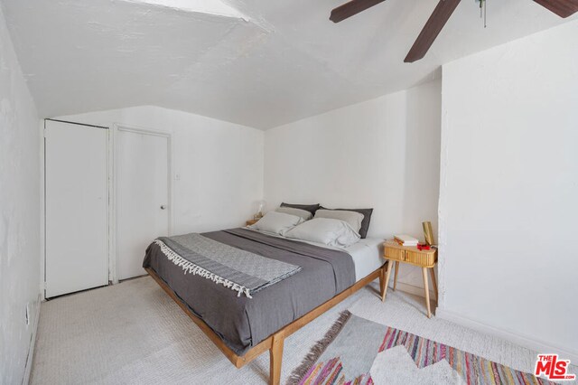 bedroom featuring ceiling fan, light carpet, and vaulted ceiling