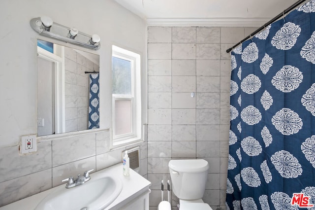 bathroom with toilet, vanity, tile walls, and crown molding