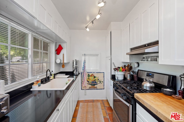 kitchen featuring sink, stainless steel gas range, and white cabinetry