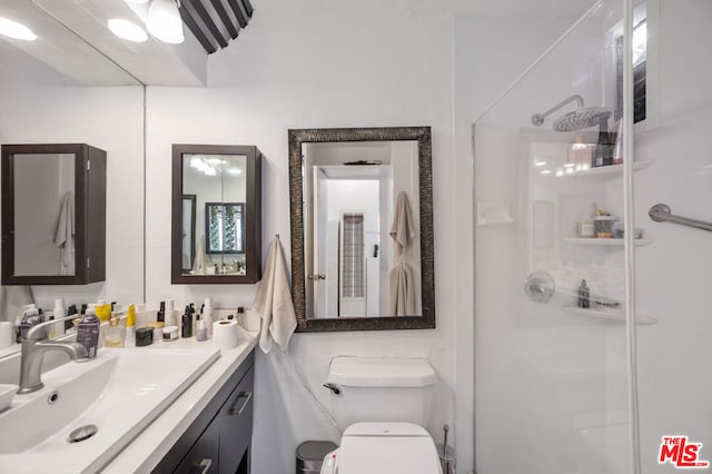 bathroom with toilet, a shower with door, and vanity