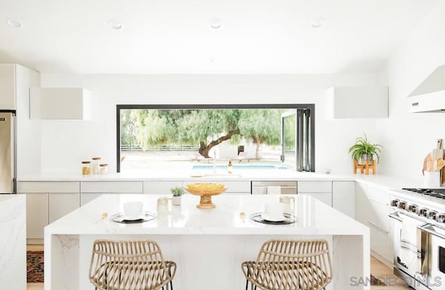 kitchen with white cabinets, sink, a kitchen breakfast bar, and stainless steel appliances