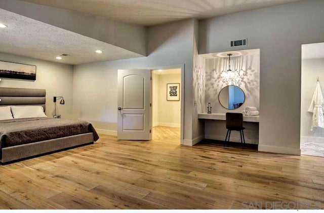 bedroom with a high ceiling, wood-type flooring, and built in desk