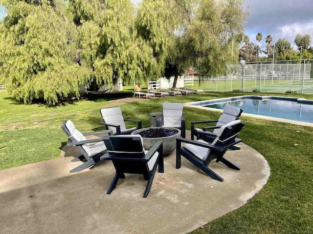 view of patio / terrace with a fenced in pool and a fire pit