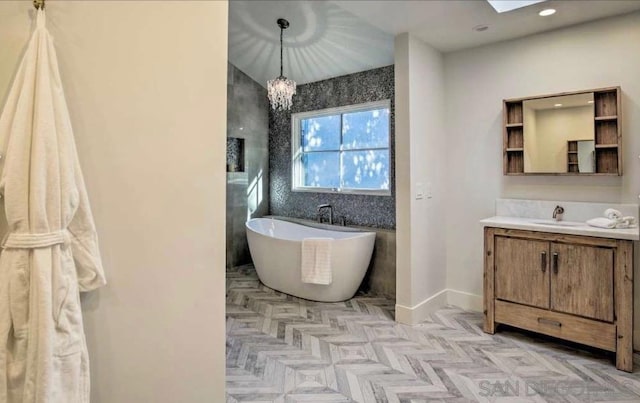 bathroom featuring a skylight, parquet floors, a bath, a chandelier, and vanity