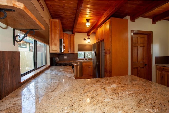 kitchen with appliances with stainless steel finishes, beamed ceiling, a healthy amount of sunlight, tasteful backsplash, and wooden ceiling