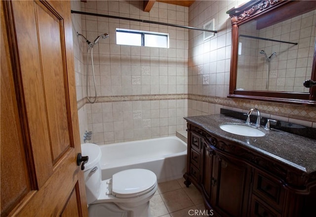 full bathroom with tile patterned floors, vanity, tile walls, toilet, and  shower combination