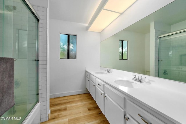 bathroom featuring hardwood / wood-style floors, combined bath / shower with glass door, and vanity