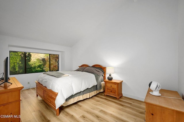 bedroom featuring lofted ceiling and light wood-type flooring