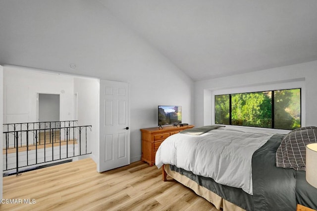 bedroom featuring high vaulted ceiling and light hardwood / wood-style floors