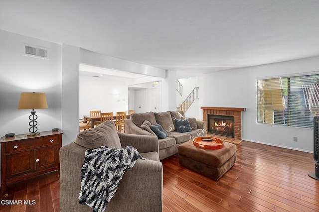 living room featuring a brick fireplace and hardwood / wood-style floors