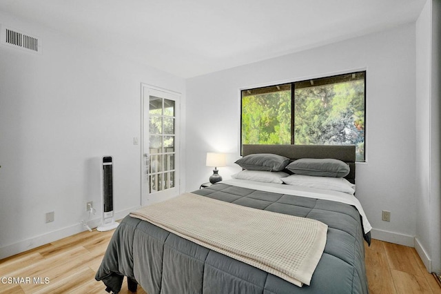 bedroom with multiple windows and hardwood / wood-style floors