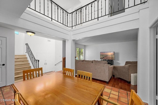 tiled dining room with a towering ceiling