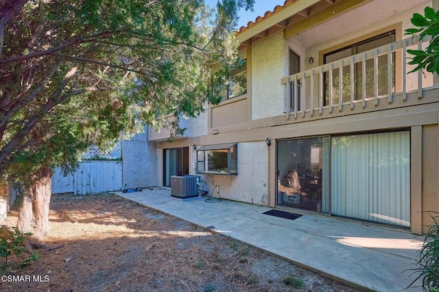 back of property featuring a balcony and central AC