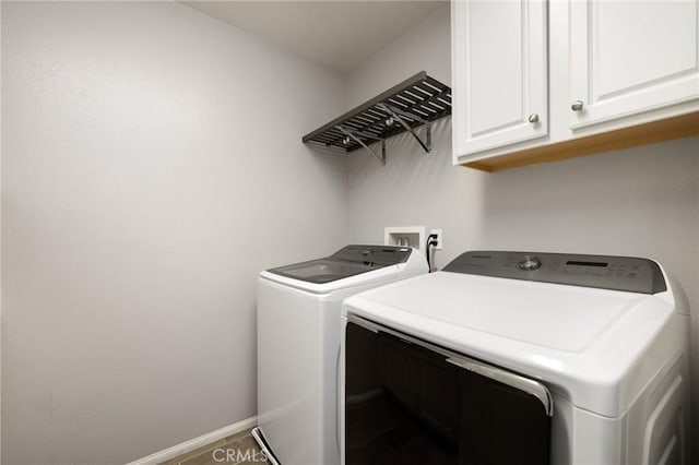 laundry area featuring washer and clothes dryer and cabinets