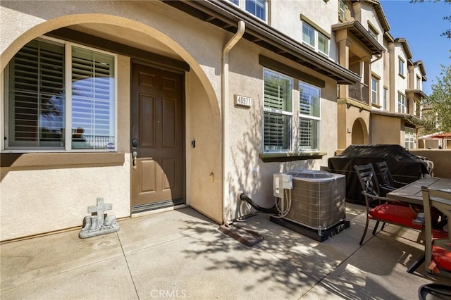 property entrance with a patio area and central AC