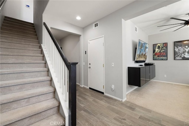 stairs featuring ceiling fan