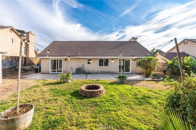 back of property featuring a patio area, a fire pit, a lawn, and central air condition unit