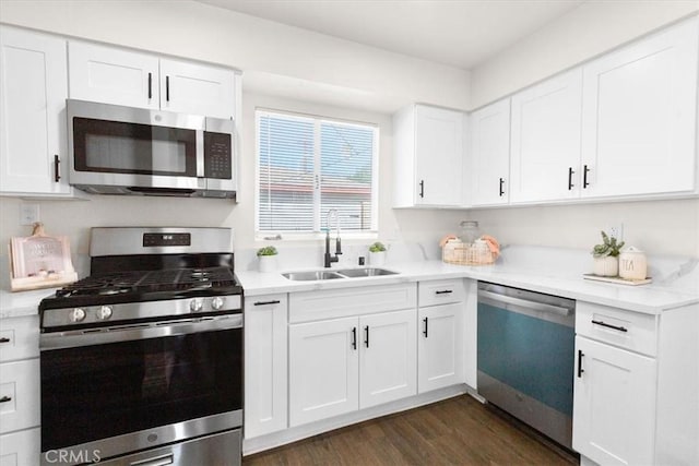 kitchen with dark hardwood / wood-style flooring, sink, stainless steel appliances, and white cabinetry