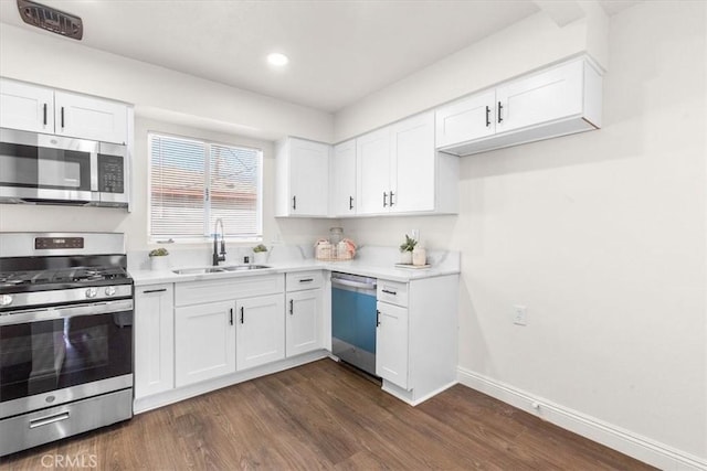 kitchen featuring sink, white cabinetry, dark hardwood / wood-style floors, and stainless steel appliances