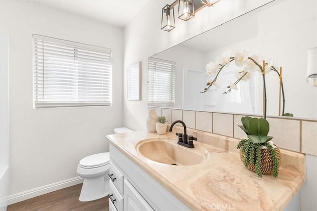 bathroom featuring toilet, vanity, and hardwood / wood-style flooring