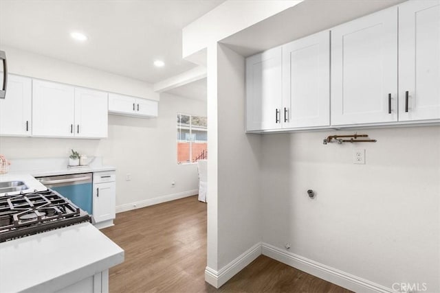 kitchen featuring stainless steel dishwasher, dark hardwood / wood-style floors, sink, and white cabinetry