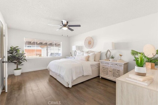 bedroom with ceiling fan, dark hardwood / wood-style floors, and a textured ceiling