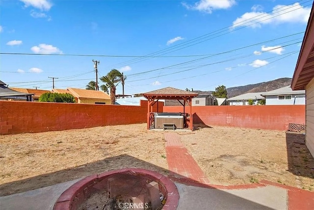 view of yard with a gazebo, a hot tub, and a fire pit