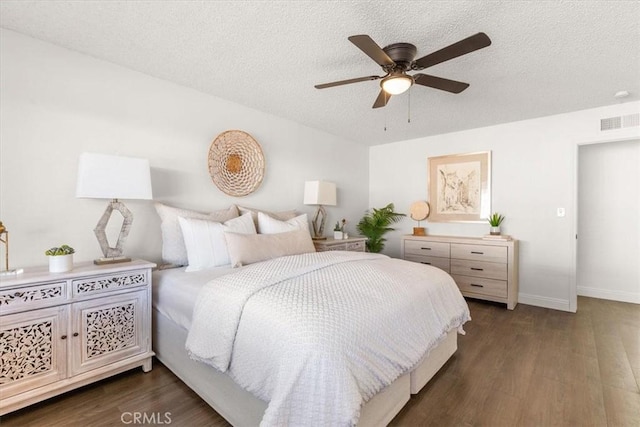 bedroom with dark wood-type flooring, ceiling fan, and a textured ceiling