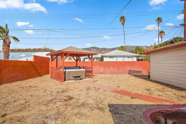 view of yard with a gazebo, a hot tub, and a water and mountain view