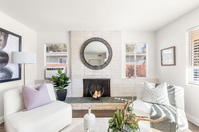 living room featuring cooling unit, a fireplace, and hardwood / wood-style flooring