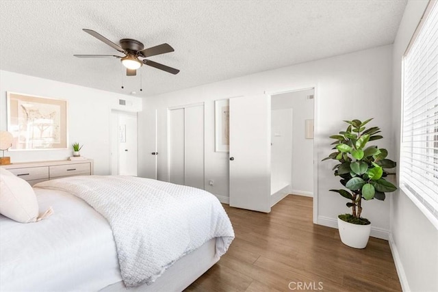 bedroom featuring ceiling fan, a textured ceiling, dark hardwood / wood-style flooring, and a closet