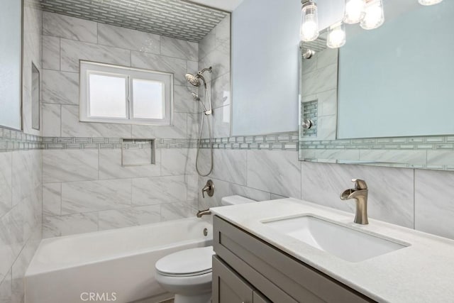 full bathroom featuring toilet, tiled shower / bath combo, tile walls, and vanity