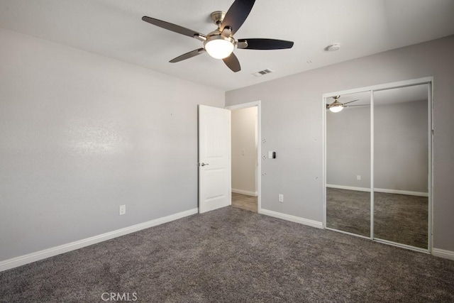 unfurnished bedroom featuring ceiling fan, a closet, and dark colored carpet