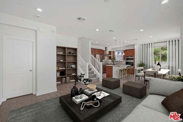 living room with hardwood / wood-style floors and sink