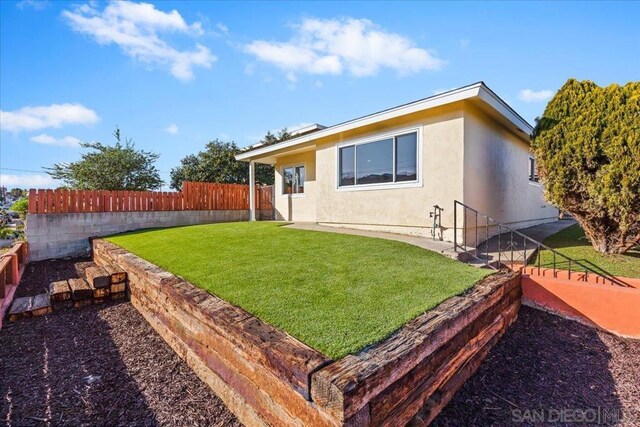 rear view of property featuring a lawn