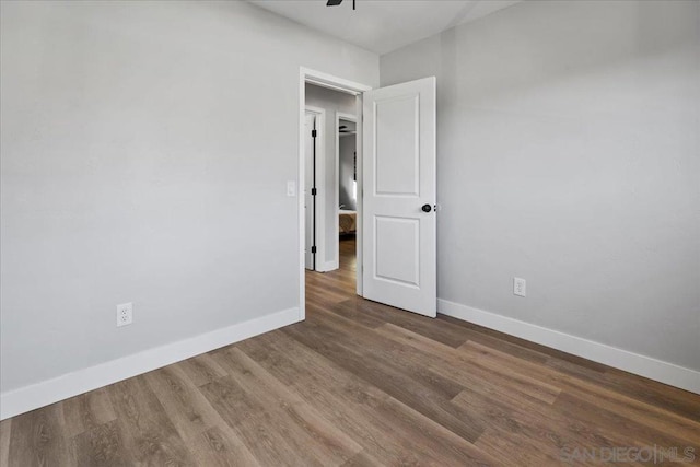 unfurnished room featuring dark wood-type flooring and ceiling fan