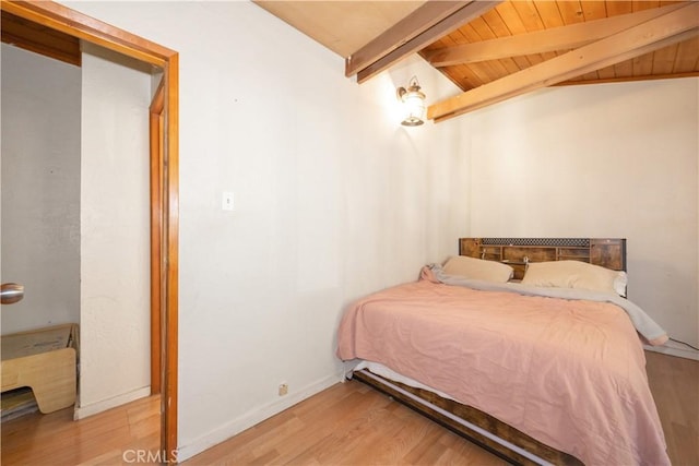 bedroom featuring vaulted ceiling with beams, wooden ceiling, and light hardwood / wood-style flooring